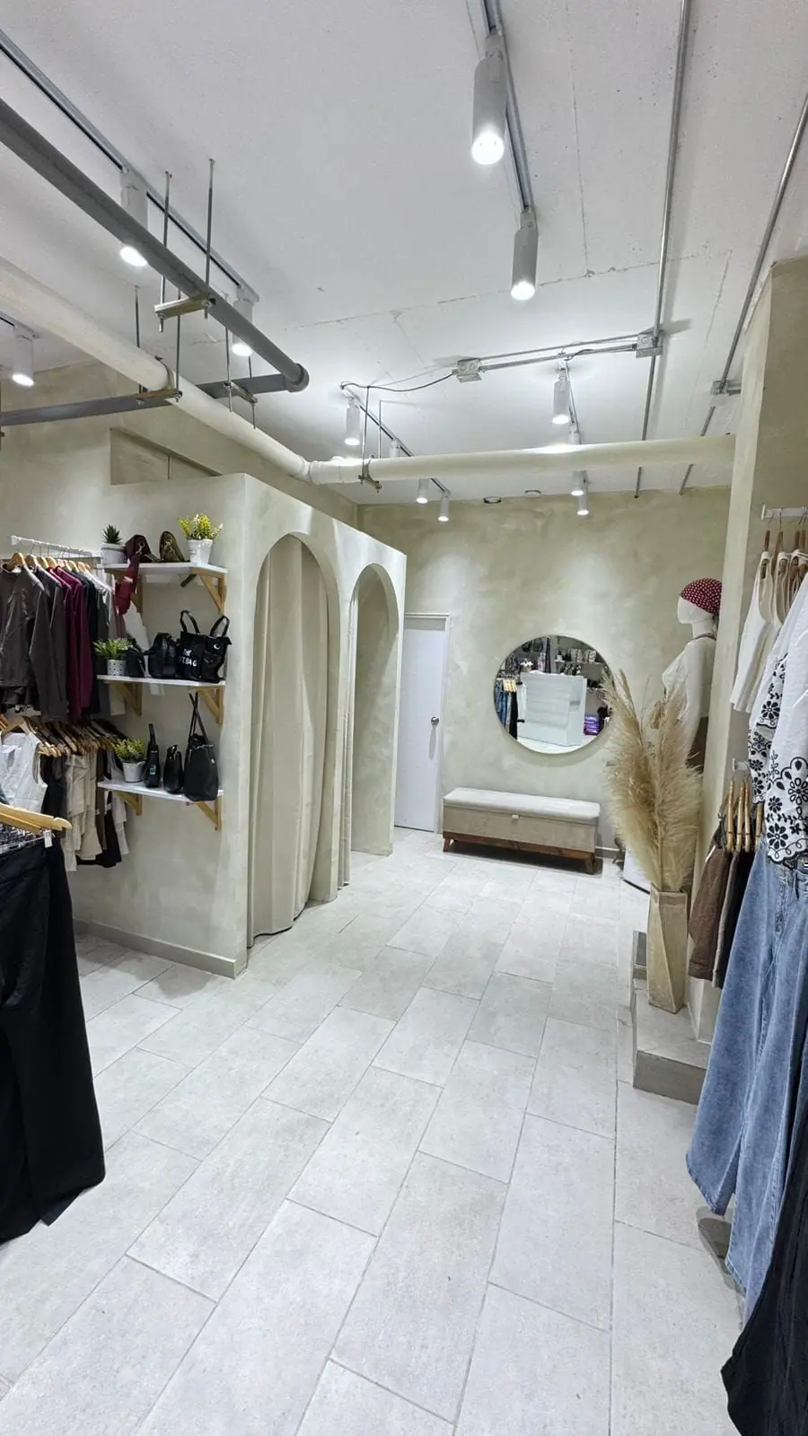Interior de la tienda Boutique W con prendas y probadores